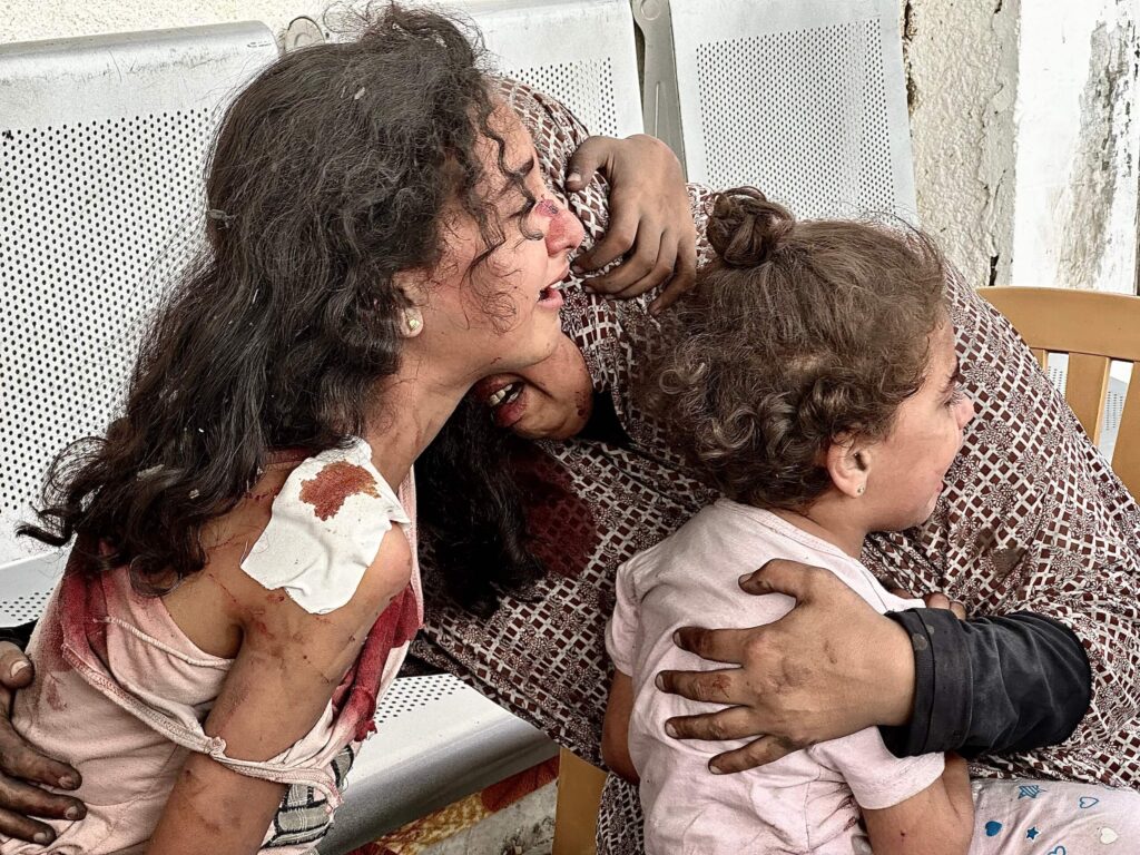 A family weeping over the loss of several members due to the bombing of their home.