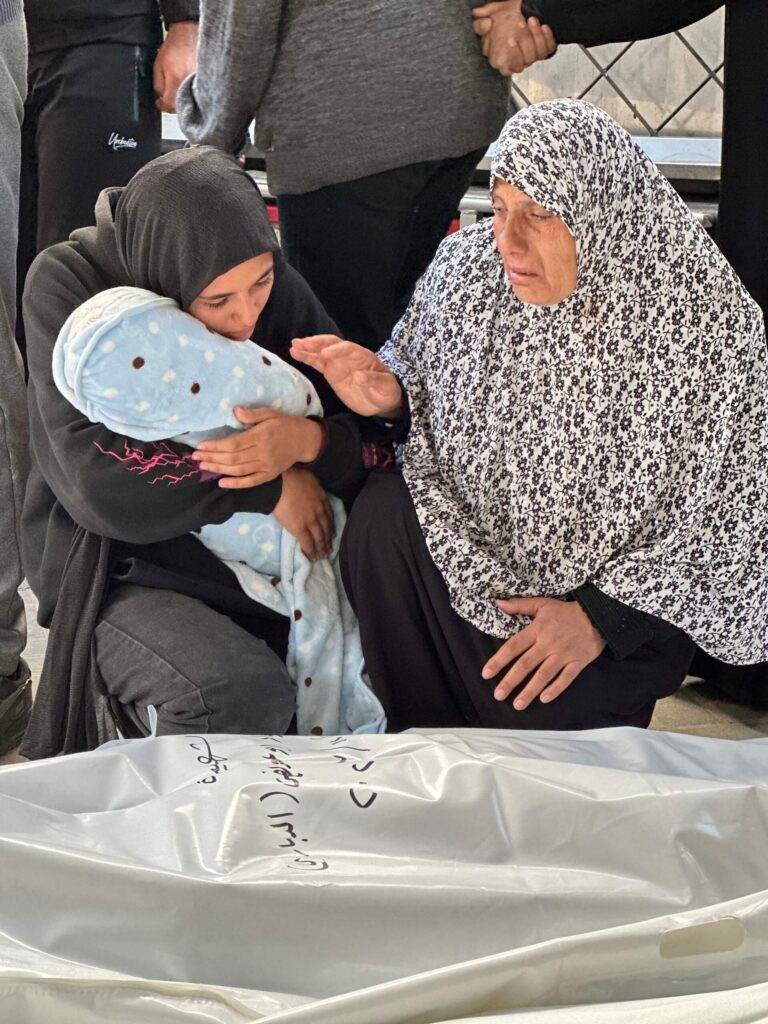 A Palestinian woman embracing her niece, whose mother and husband were martyred in the bombing of a house in eastern Rafah.